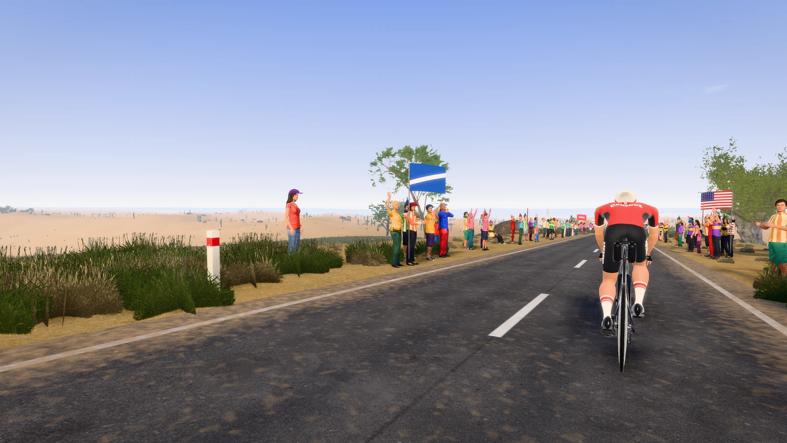 Een renner op een warme, droge weg in Kona, met toeschouwers en een vlag.